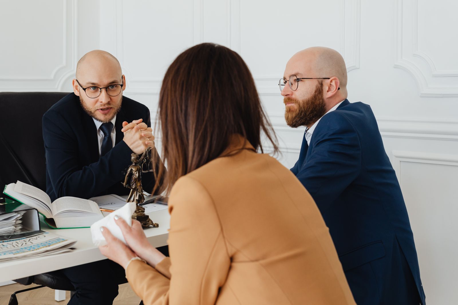 Un abogado reunido con sus clientes en el despacho